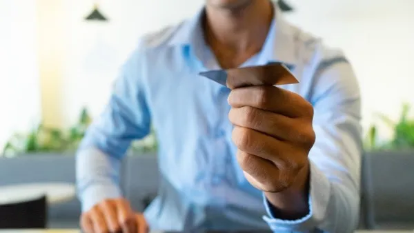 A close-up of a businessman handing over a business card at a meeting.
