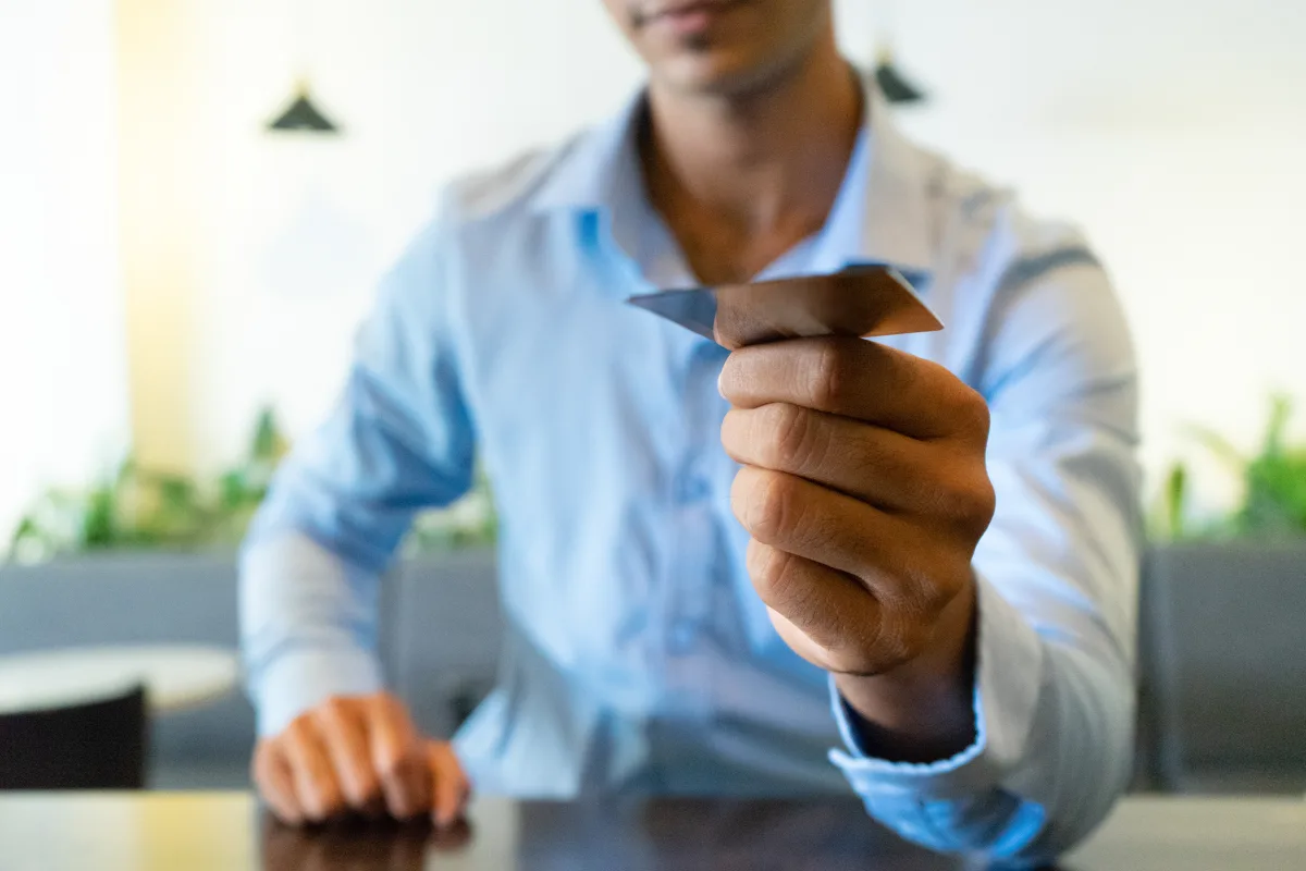 A close-up of a businessman handing over a business card at a meeting.