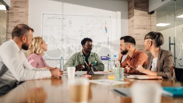A marketing team around a meeting table working through a campaign plan.